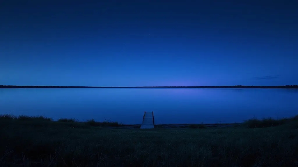 Lake Ray Hubbard at blue-hour twilight, a lone dock reaching into still water beneath a wide dusk sky.