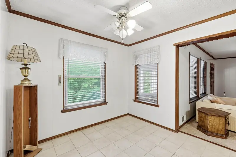 Breakfast nook with tile floor, wood trim and windows, open to the carpeted living area