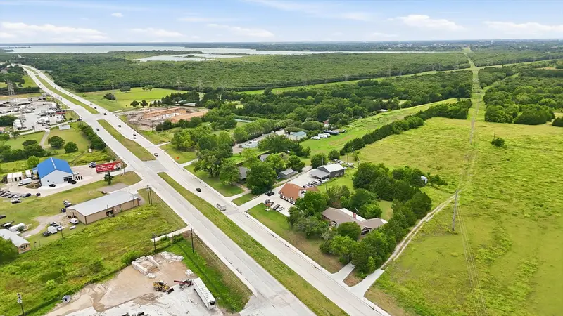 High aerial vista down the State Highway 205 corridor with green fields and Lake Lavon on the horizon