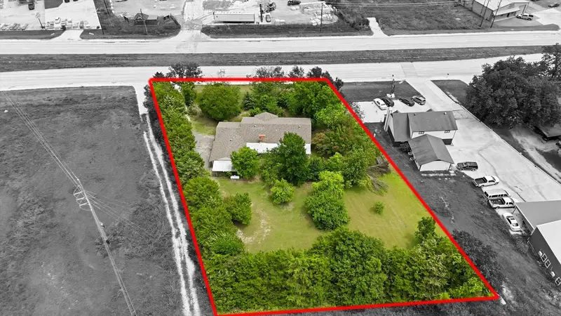 Overhead aerial with the approximate property boundary outlined in red, the lot in color and surroundings in black and white