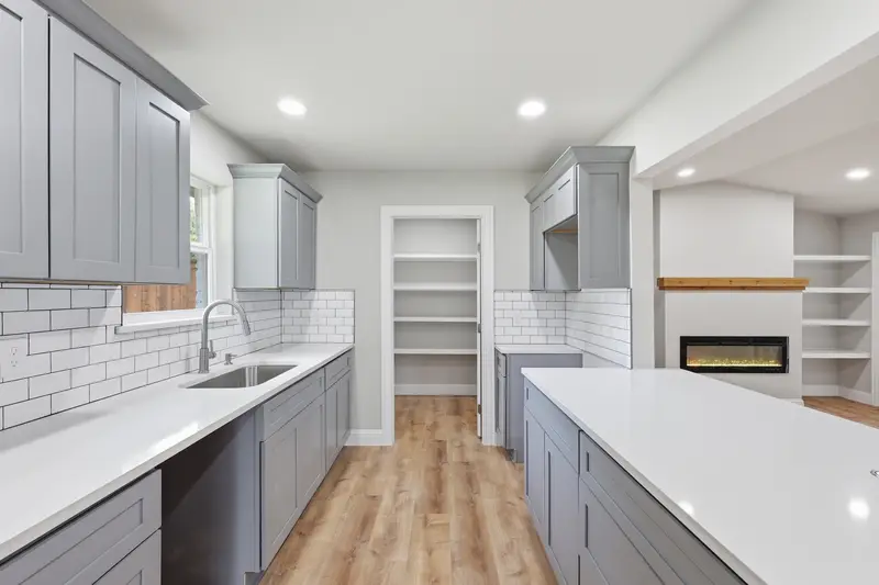 Gray kitchen with quartz counters and a walk-in pantry with wrap-around shelving
