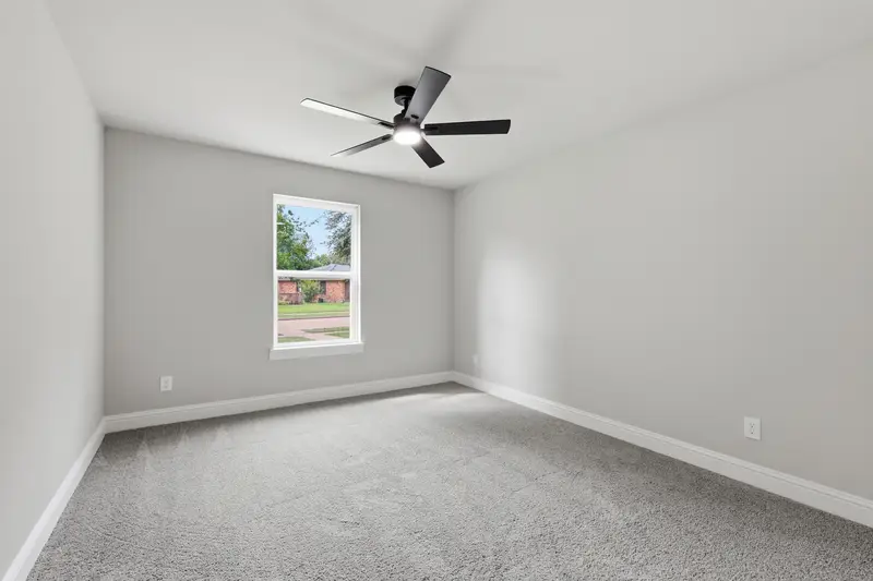 Carpeted bedroom with a front-facing window and ceiling fan