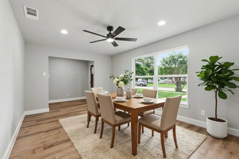 Virtually staged formal dining room with a six-seat table by the front window